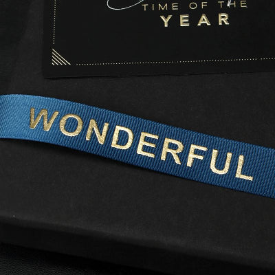 Elegant reusable ribbon with logo, folded neatly on branded product packaging.